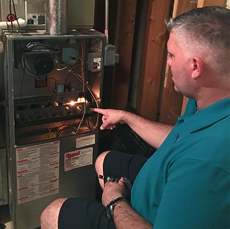 Service technician cleaning a furnace