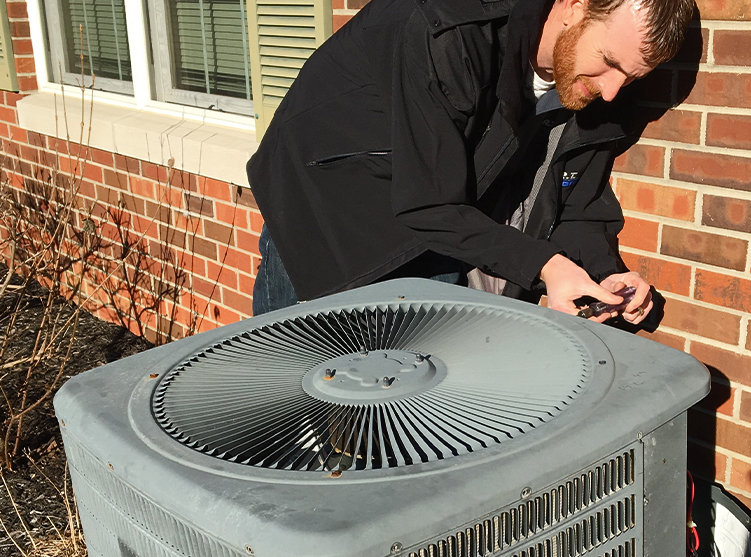 RT Moore Service Technician Repairing an HVAC